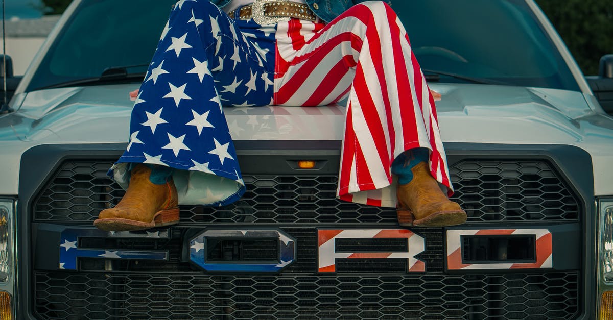 Lag In Singleplayer - Legs of a Woman Wearing American Flag Pants Sitting on Top of a Car Hood