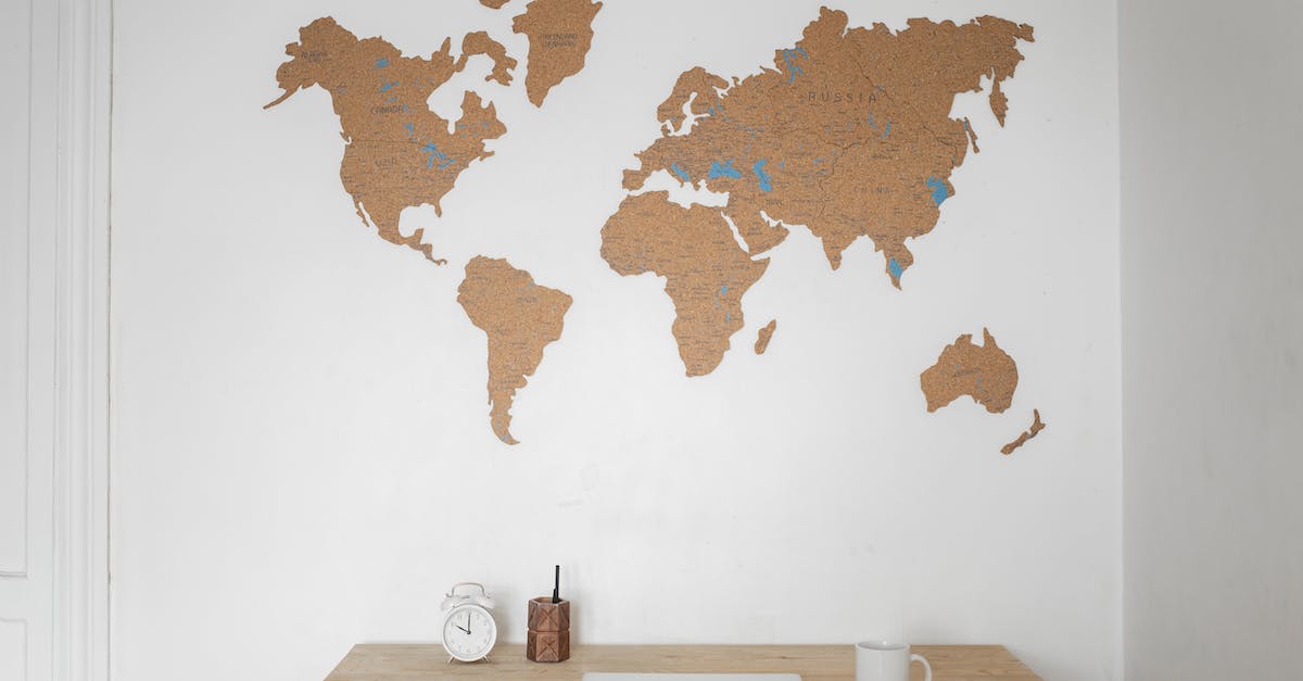 Languages available as commentary in FIFA World Cup Brazil 2014 - Alarm clock near pen container with cup and laptop on table placed near silhouettes of world map on wall