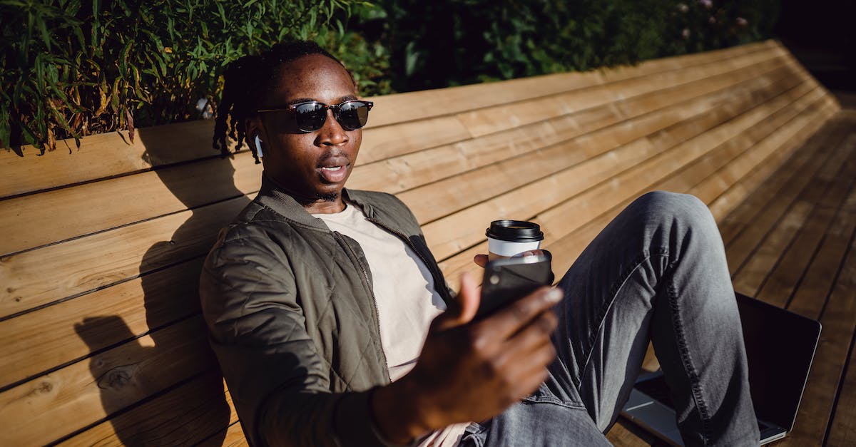 Leaping shot op in Online mode? - Young black man taking selfie on bench in park Leaping shot op in Online mode? - Young black man taking selfie on bench in park