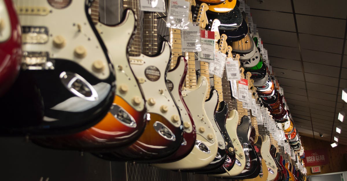 Les Paul and Fender Stratocaster - Electric Guitar Hanging Near Wall