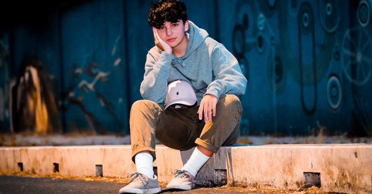 Level cap in Blitzball? - Stylish adolescent resting on sidewalk in evening Level cap in Blitzball? - Stylish adolescent resting on sidewalk in evening