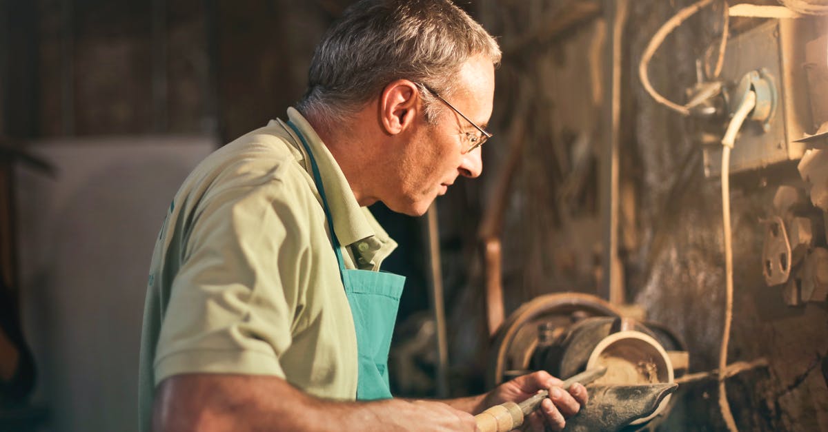 Lightning Bow Affecting Only Certain People - Senior male turner working on lathe machine in workshop Lightning Bow Affecting Only Certain People - Senior male turner working on lathe machine in workshop