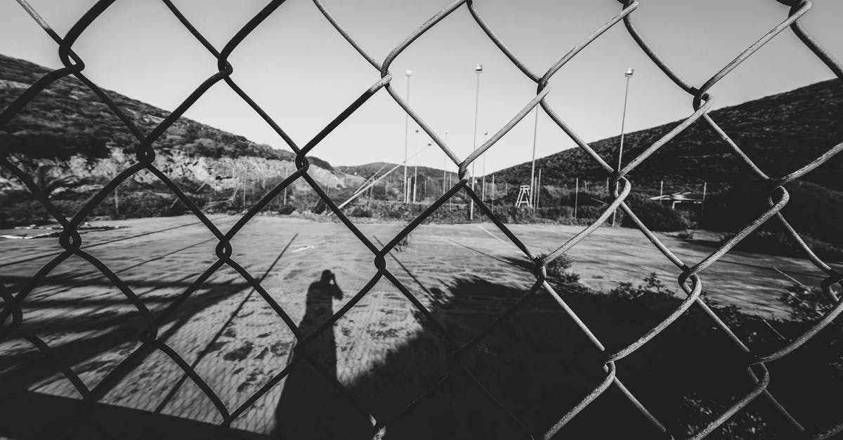 Linking battle net account to psn - Through metal net fence of black and white sports ground surrounded by mountains on sunny day