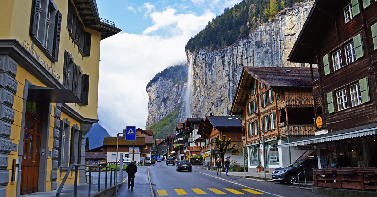 Locked myself out at the waterfall location - Small town located among rocky mountains with small waterfall in sunny day