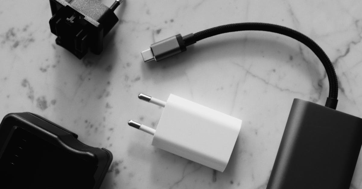 Logging in on a different phone - Composition of various modern charging units with adapter and small black external battery with short cable placed on white marble table