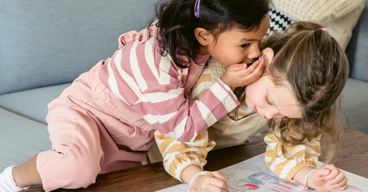 Mage Secret Duplicate interaction with AoE damage [duplicate] - Attentive Hispanic child whispering in ear of girlfriend coloring paper drawing with crayon at table in house