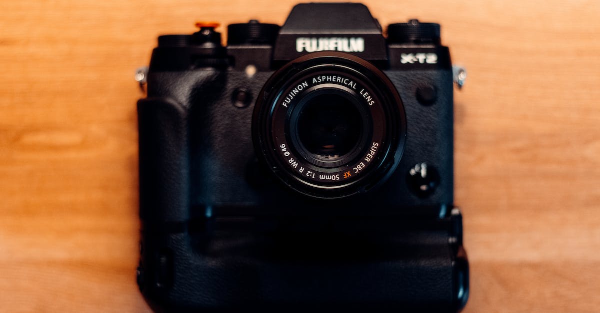 Magnet and Delete button from Not Enough Items doesn't appear - Top view of body of modern black digital photo camera with small round aspherical lens on wooden table