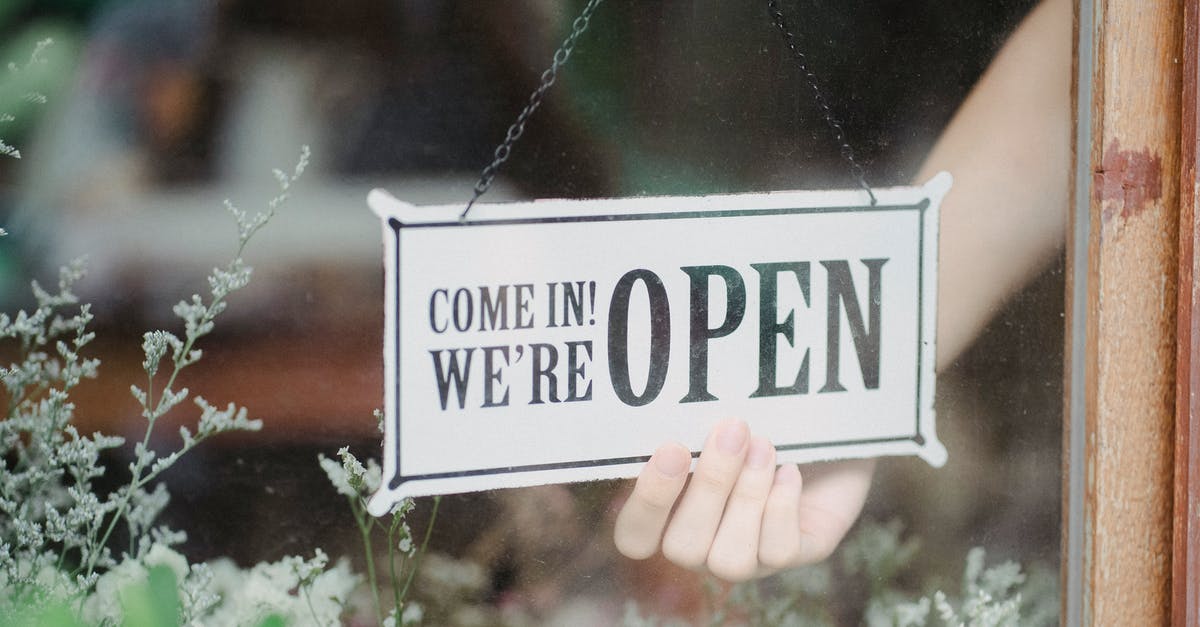 Make squad open to public - Crop anonymous person flipping signboard on window of floral shop in modern city Make squad open to public - Crop anonymous person flipping signboard on window of floral shop in modern city