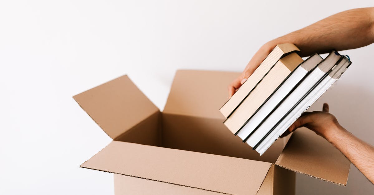 Making a book with clickable buttons to move to Spawn, The Nether and The End [duplicate] - Crop unrecognizable male packing staked books into carton box while standing against white wall during relocation