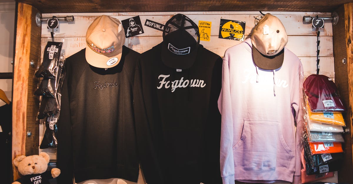Markets are visible and highlight but not accessible - Colorful trendy clothes hanging on counter with wooden elements in stylish store in daytime