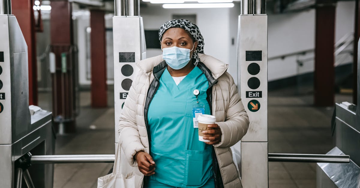 MCSM season 2 episodes and season pass 'unavailable' - Calm adult African American nurse with coffee to go wearing warm outfit and protective face mask passing through turnstile in metro station and looking at camera