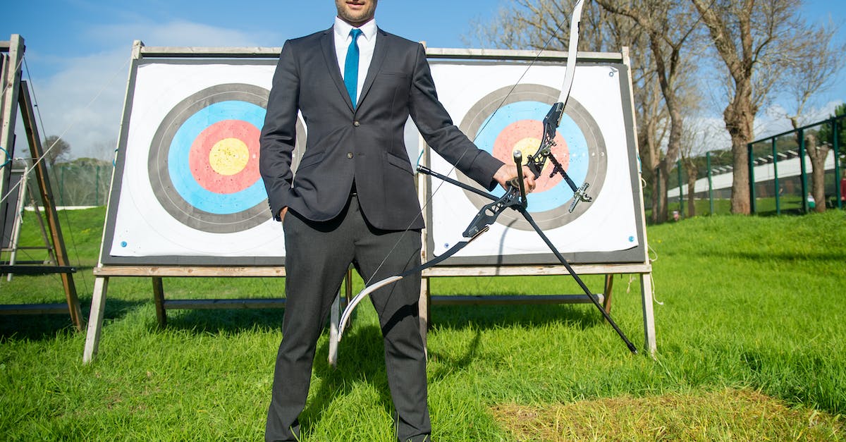 Minecraft Arrow Targets [duplicate] - Man in Formal Wear Holding Compound Bow and Arrow Infront of Archery Target Board