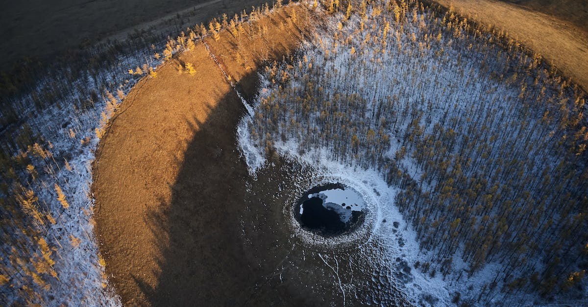 Minecraft black terrain and texture bug - From above of round black puddle with glares on surface located in sand cavity in evening time