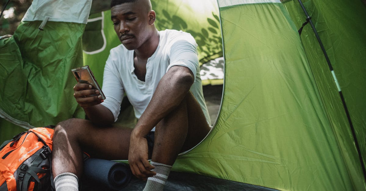Minecraft disconnection timeout, aiding bad connection players [closed] - Sad African American male traveler resting in tent and browsing Internet on cellphone while spending journey in nature