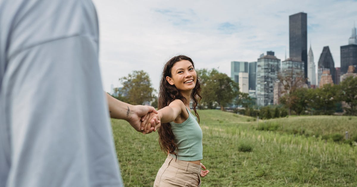 Minecraft for me and my girlfriend [duplicate] - Crop anonymous man holding hand and following happy young ethnic girlfriend while spending time together in green park in New York