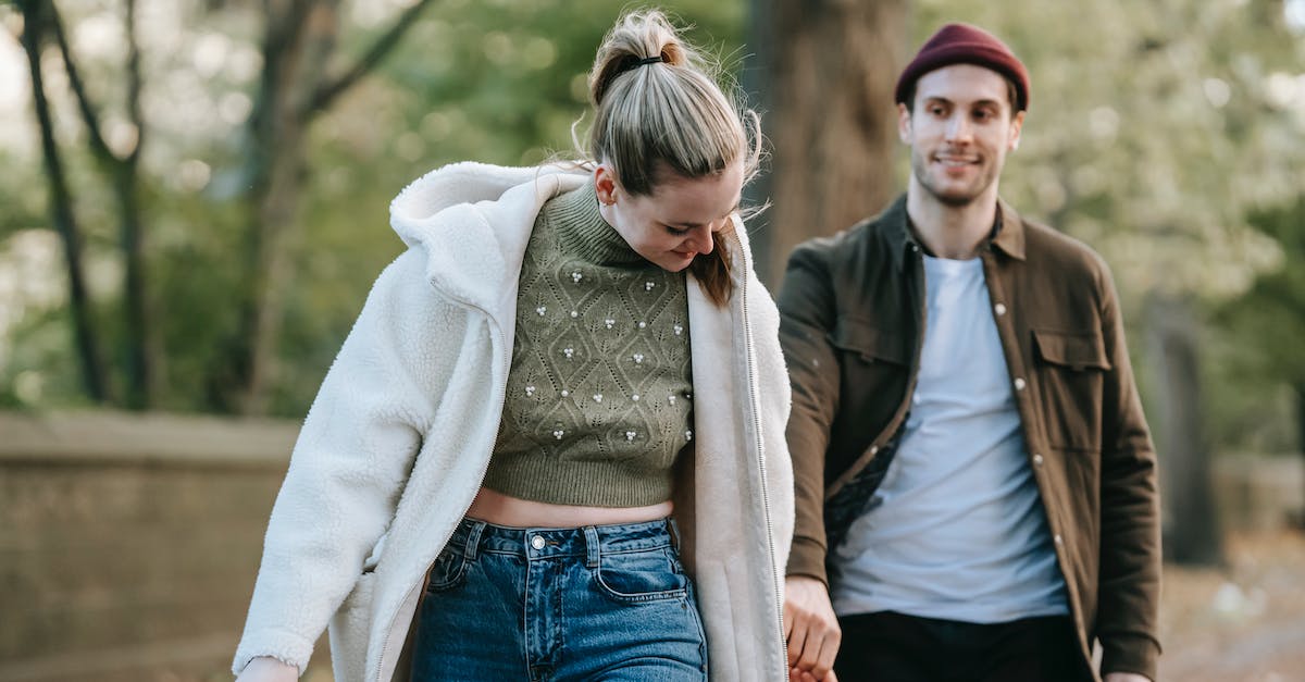 Minecraft for me and my girlfriend [duplicate] - Cheerful young stylish lady in warm clothes holding hand of smiling boyfriend while walking together in park on sunny autumn day
