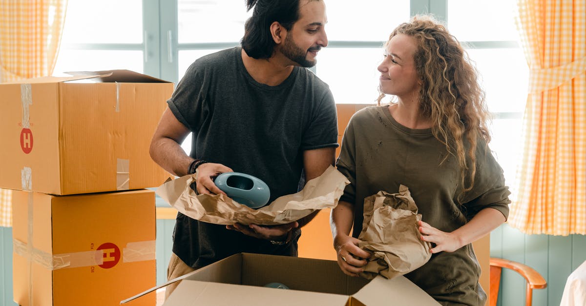 Minecraft generates a new nether portal in a different location that's not my home portal - Multiethnic couple packing ceramic belongings in parchment before relocation