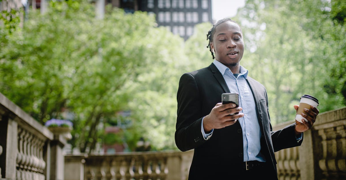 Minecraft: I have a good ping but can't connect - Positive young black man with smartphone and takeaway coffee in city park Minecraft: I have a good ping but can't connect - Positive young black man with smartphone and takeaway coffee in city park