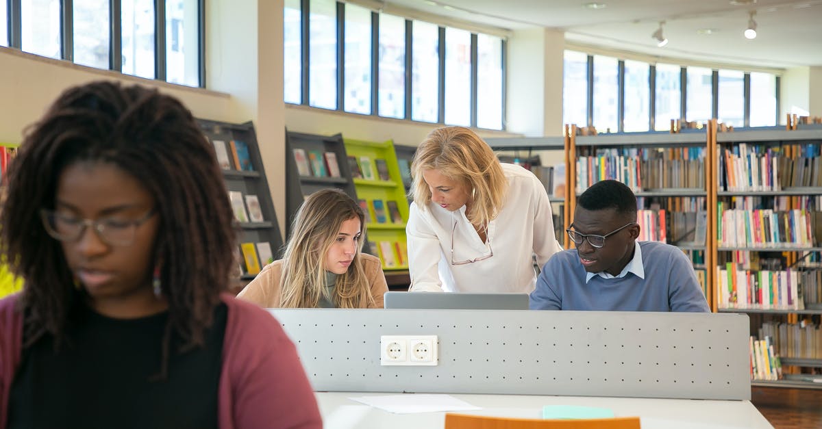 Minecraft SelectedItem: help with block data tags? [duplicate] - Elegant middle aged female library worker helping to young multiracial students to find information during work on laptop