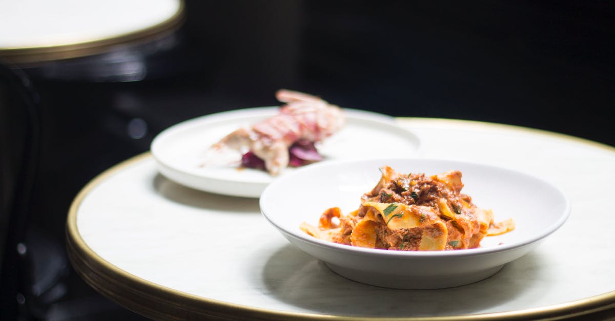 Missing my last bird in Botanicula, at restaurant - Bowl with pasta with meat near plate with roasted bird