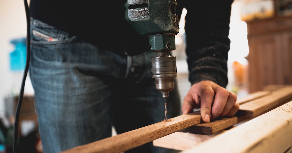 Missing options in carpenter's workbench - Man Holding Wooden Stick While Drilling Hole Missing options in carpenter's workbench - Man Holding Wooden Stick While Drilling Hole