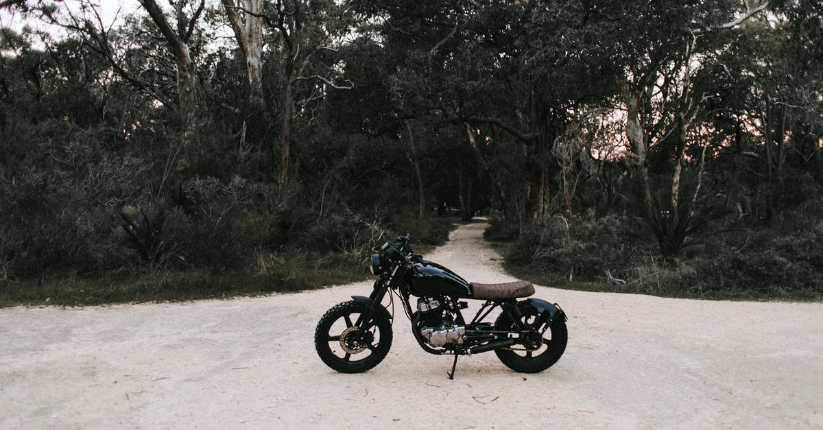 Motor skill: Let speed come naturally? - Black metal motorbike parked on sandy road near trees and green grass in daytime Motor skill: Let speed come naturally? - Black metal motorbike parked on sandy road near trees and green grass in daytime