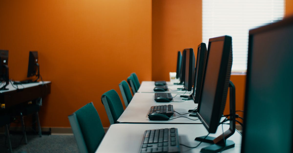 Mouse Leaving the Game Window - Modern computers with keyboards and mice placed in row on table with chairs in contemporary workplace with orange walls Mouse Leaving the Game Window - Modern computers with keyboards and mice placed in row on table with chairs in contemporary workplace with orange walls