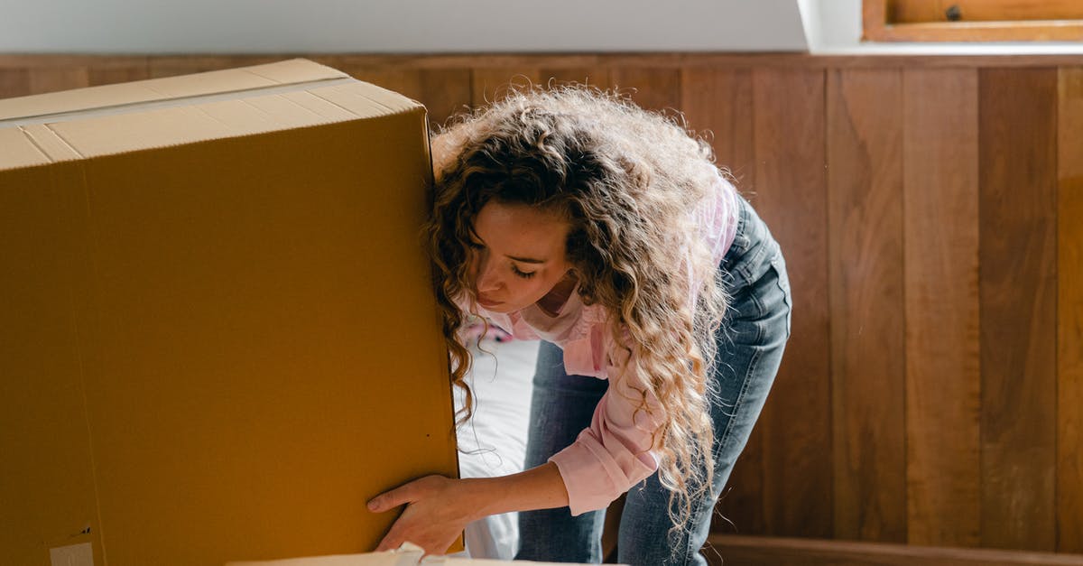 Move one PS4 hard disk to another - Young woman unpacking boxes in light apartment Move one PS4 hard disk to another - Young woman unpacking boxes in light apartment