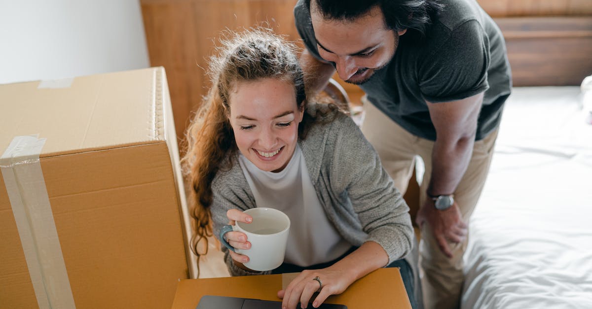 Move online resources to offline resources - Happy multiracial couple surfing internet on laptop while drinking coffee Move online resources to offline resources - Happy multiracial couple surfing internet on laptop while drinking coffee