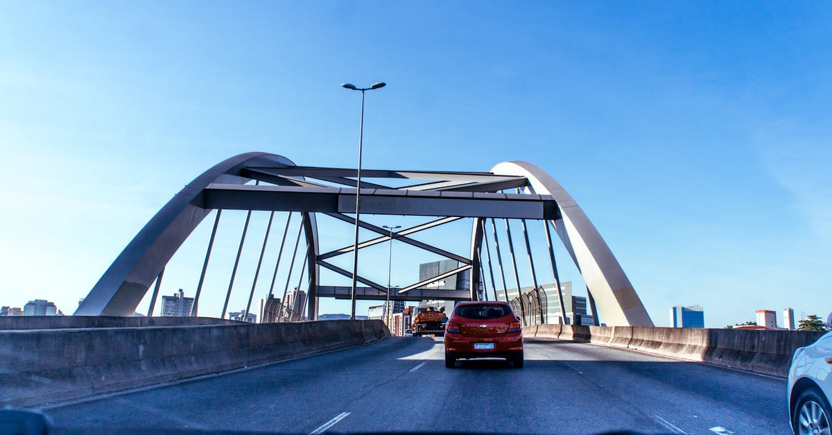 Moving at higher speed than normal in geometry dash - Exterior of contemporary bridge with traffic under clear blue sky through automobile window