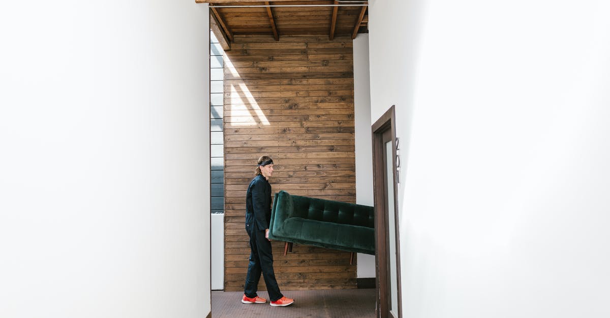Moving furniture from one settlement to another [duplicate] - Man in Carrying a Green Sofa