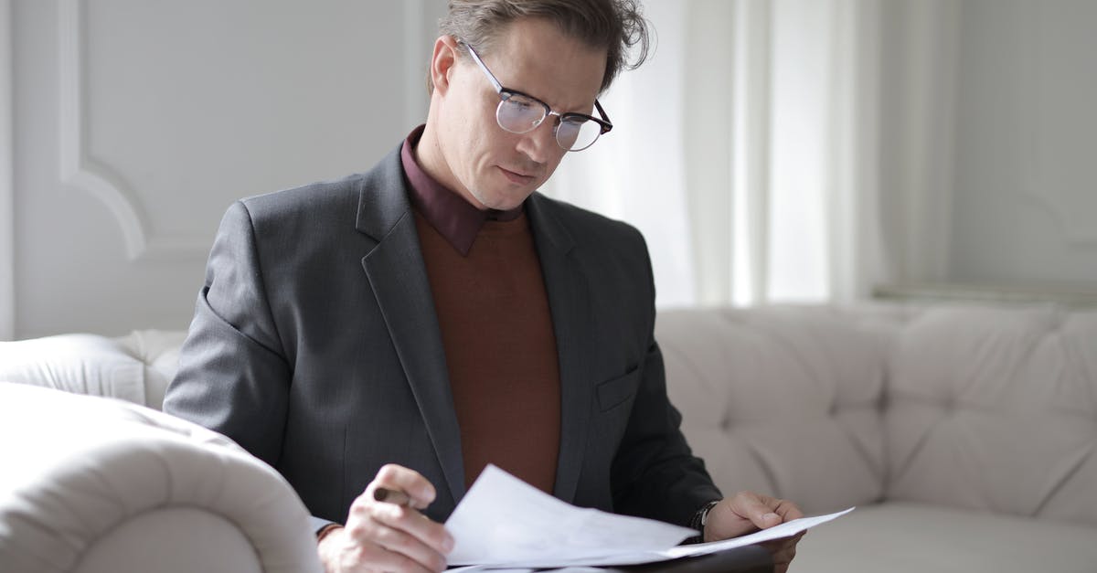 Multiple commands in a given sign doesn't execute correctly...? - Elegant adult man in jacket and glasses looking through documents while sitting on white sofa in luxury room
