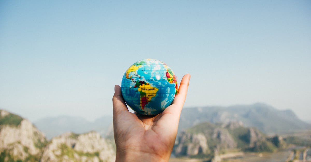 Multiple games linked to one world - Person Holding World Globe Facing Mountain Multiple games linked to one world - Person Holding World Globe Facing Mountain