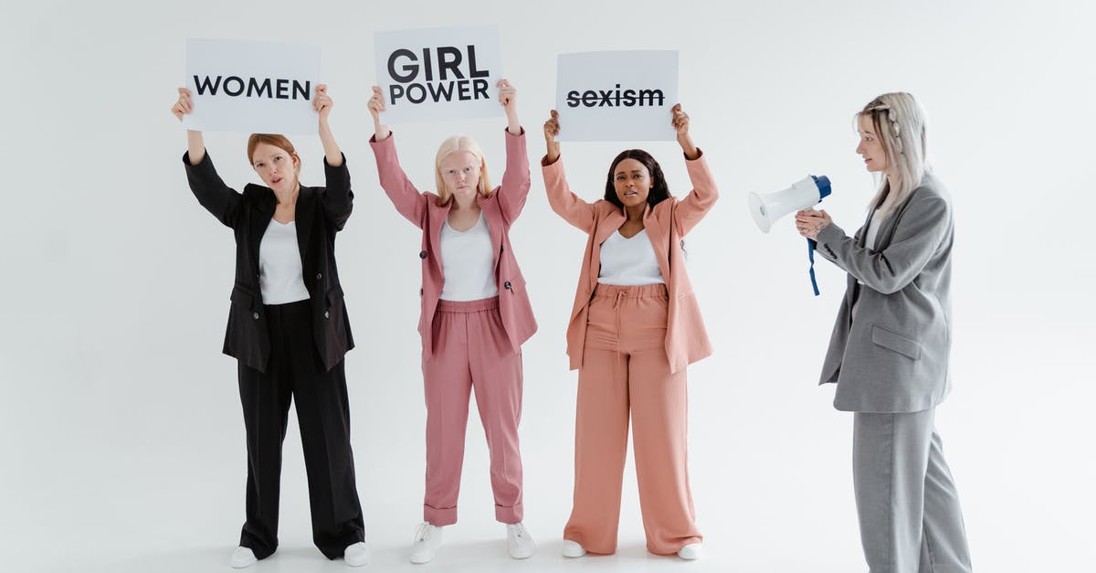 Multiple subfaction leaders - A Woman in Gray Blazer and Pants Using a Megaphone while Standing Near the Women Holding Placards Multiple subfaction leaders - A Woman in Gray Blazer and Pants Using a Megaphone while Standing Near the Women Holding Placards