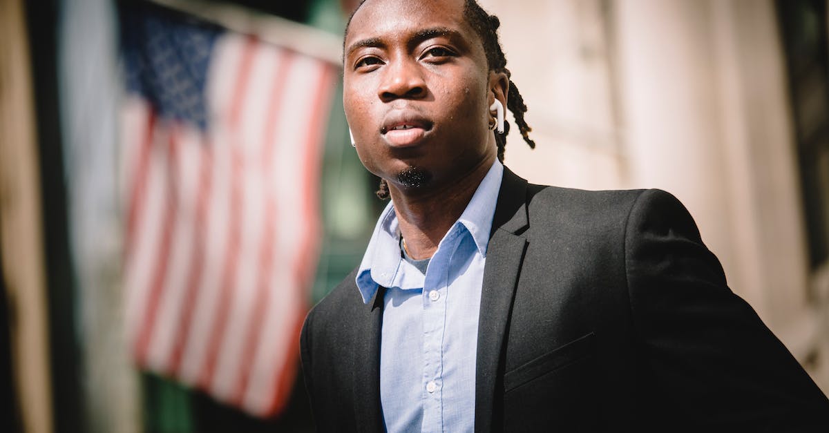 My citizens are too smart - Serious black businessman against blurred building with American flags