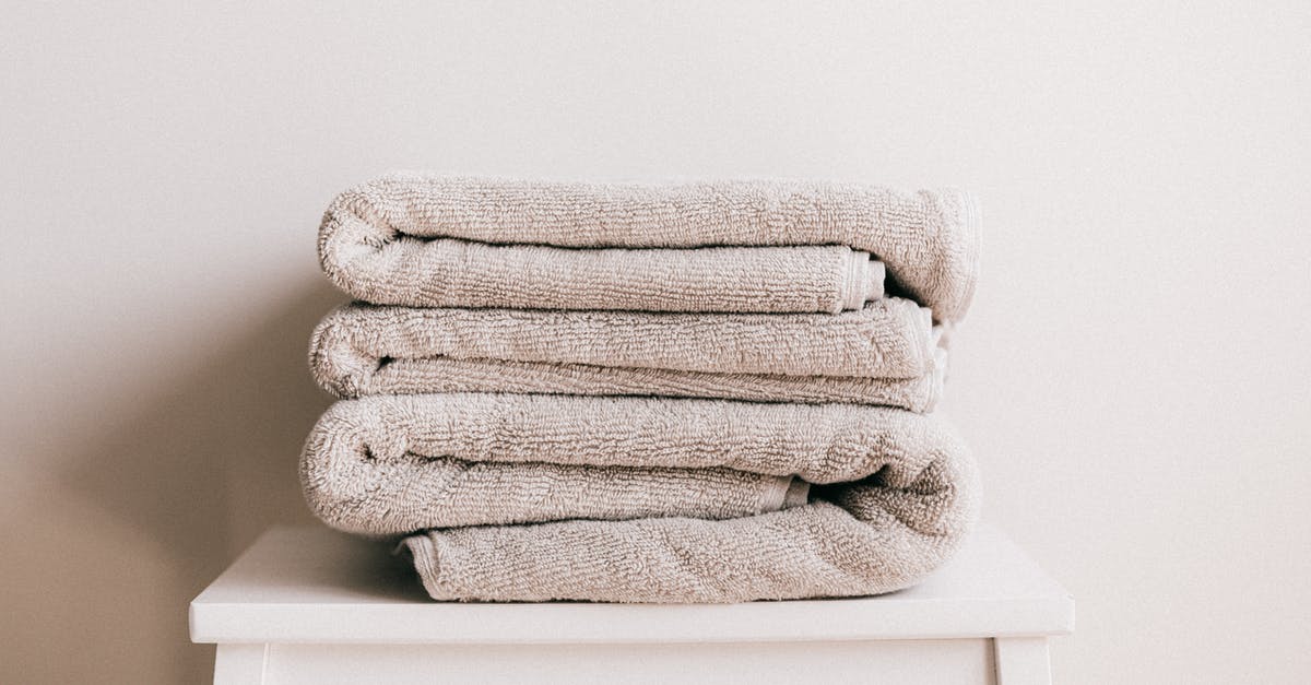 My follower's body turns grey - Stack of soft clean light beige folded towels placed on white minimalist stool against beige wall in daylight My follower's body turns grey - Stack of soft clean light beige folded towels placed on white minimalist stool against beige wall in daylight