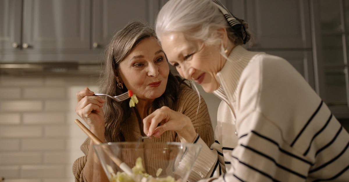 My food is very low - An Elderly Women Eating Salad in the Kitchen My food is very low - An Elderly Women Eating Salad in the Kitchen