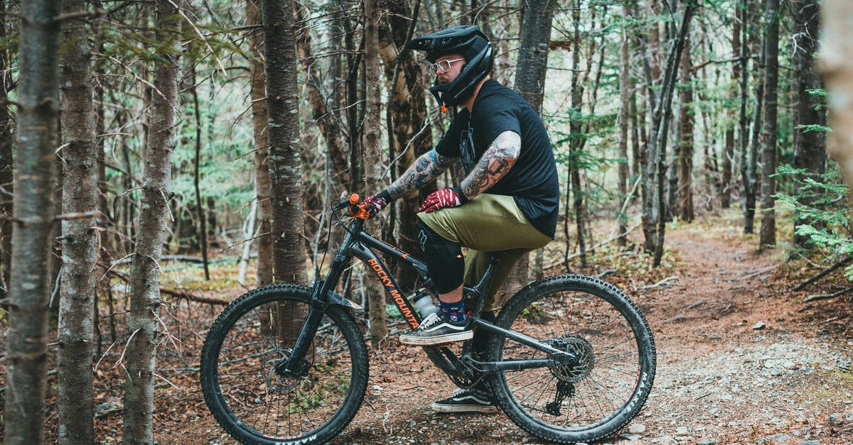 My helmet durability is 0? - Man in Black Jacket Riding on Black and Red Mountain Bike in Forest