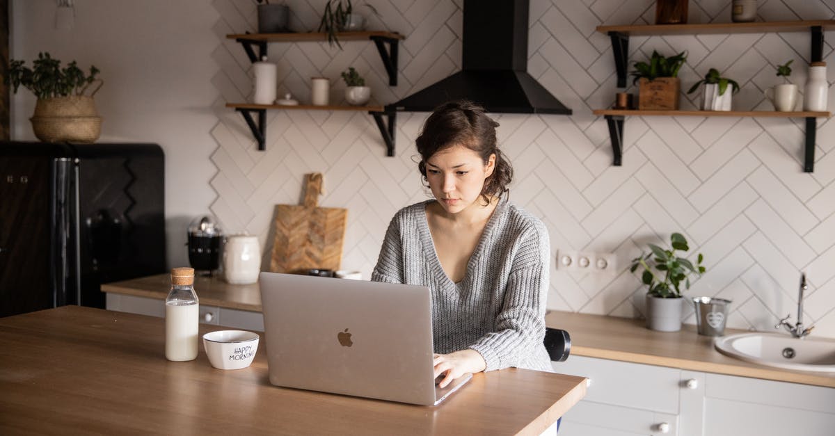 My laptop is unable to efficiently choose the right GPU - Content young woman browsing laptop in modern kitchen