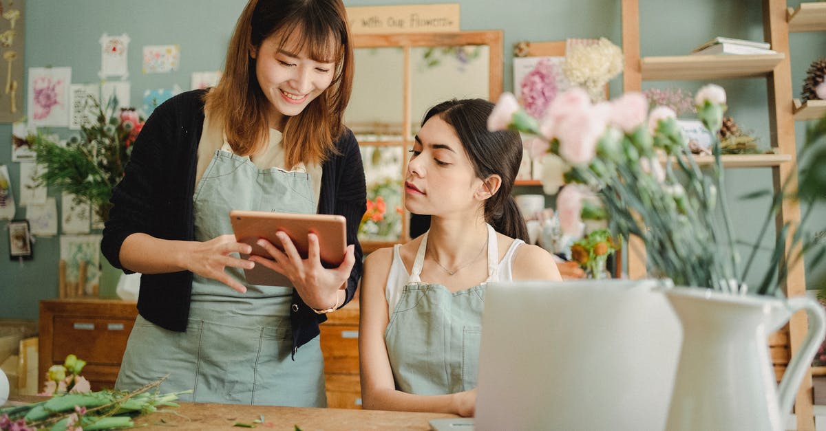 My laptop is unable to efficiently choose the right GPU - Content multiethnic female coworkers at table with flowers surfing tablet while choosing design for bouquet during work in florist shop