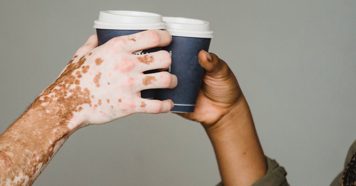 My Minecraft skin has been turned inside out - Unrecognizable man with vitiligo skin and anonymous African American male clinking with hot drinks on gray background during coffee break