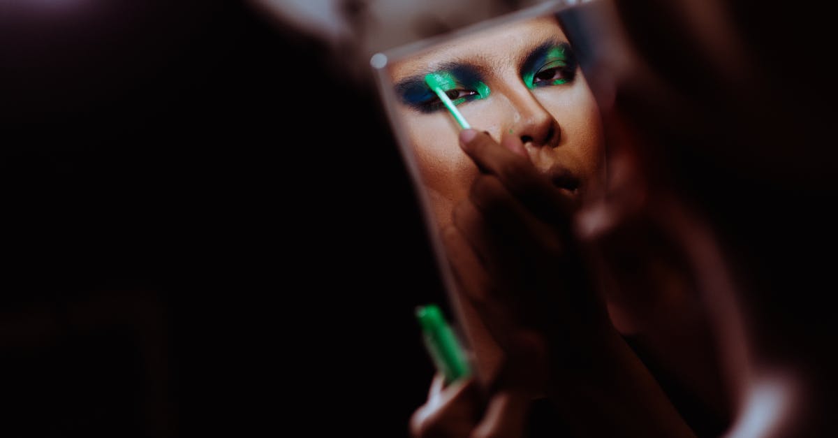 My minecraft skin looks semi-transparent, how can I fix it back? - Back view of crop Asian female with mirror applying green eye shadow on eyelid while looking at camera My minecraft skin looks semi-transparent, how can I fix it back? - Back view of crop Asian female with mirror applying green eye shadow on eyelid while looking at camera