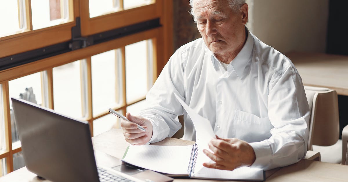 My steam account is logging into my old account, how do i fix [closed] - Serious gray haired aged man in white shirt sitting at table and browsing laptop while checking notes in modern office