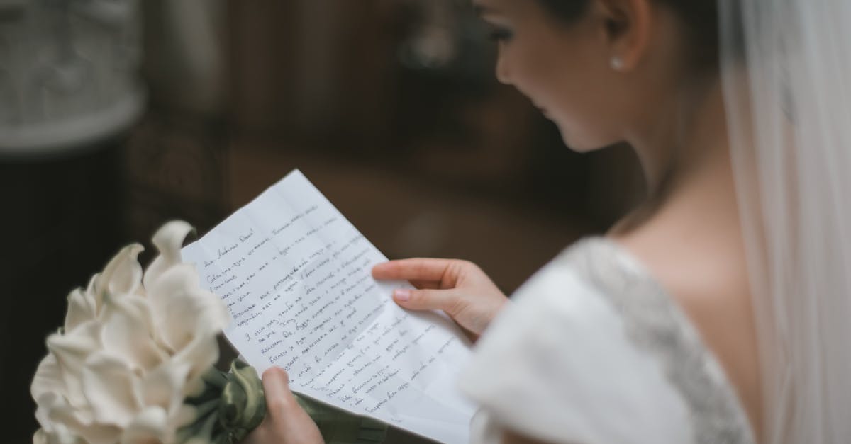 My wife disappeared, but we're still married. How can I fix this? - Back view of crop charming bride in white dress and veil reading wedding vow on paper sheet with bouquet of arum lilies during weeding ceremony