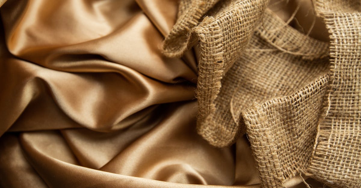my wii had a wrap on it but the surface is now rough - Top view draped golden satin fabric and mesh rattan cane webbing placed on table as background