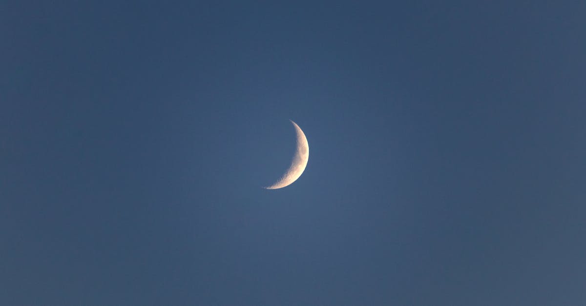 Mysterious White Dogtag - Bright narrow white crescent in blue peaceful sky in late dusky calm evening Mysterious White Dogtag - Bright narrow white crescent in blue peaceful sky in late dusky calm evening