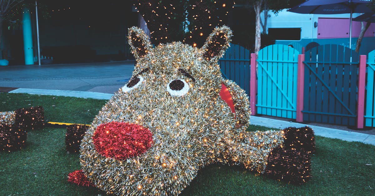 Named giant animal - Big funny figure of animal with red nose and shiny lights of garlands in playground