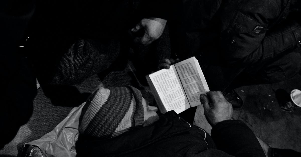 Need help with controls - Black and white of homeless man lying on floor and reading book in night shelter for homeless