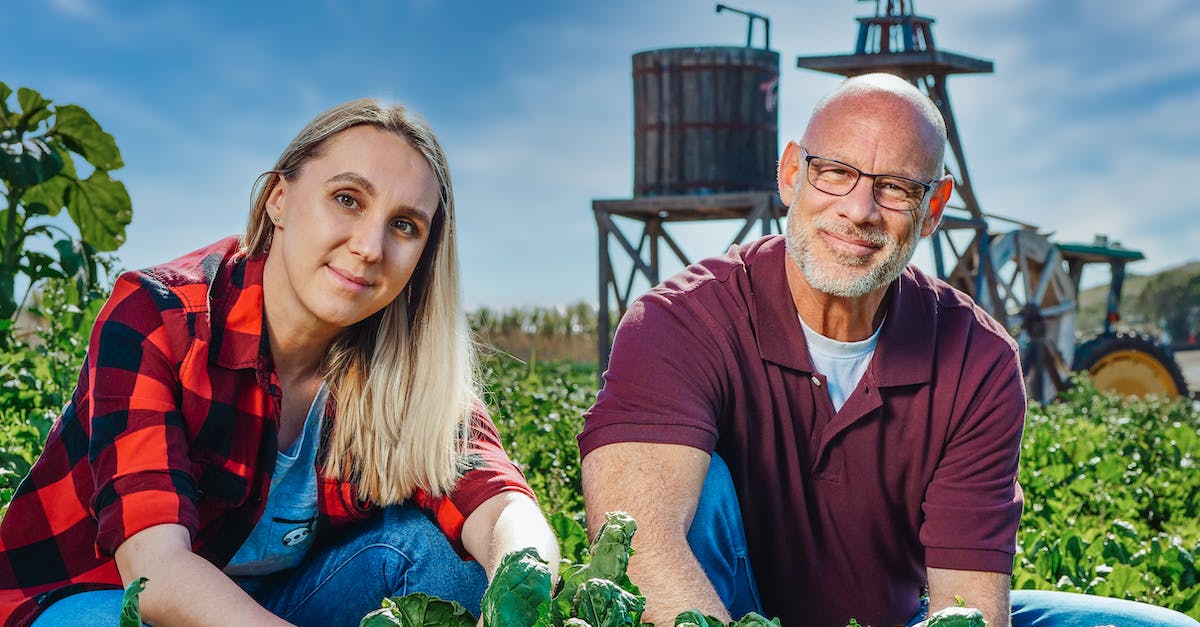 Needs unrotten DRINK_MAT-producing plants - Man and Woman Sitting on a Cropland Needs unrotten DRINK_MAT-producing plants - Man and Woman Sitting on a Cropland