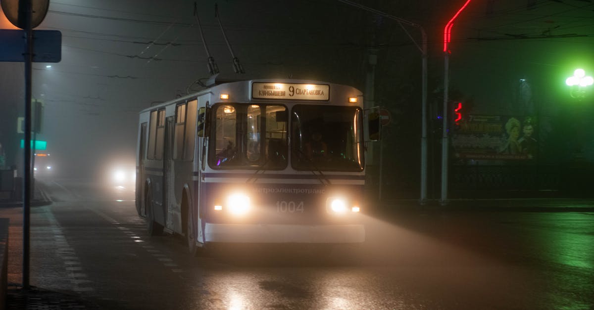 Nethack move past seemingly unpassable area - Old trolleybus driving along wet asphalt road in small city at foggy night